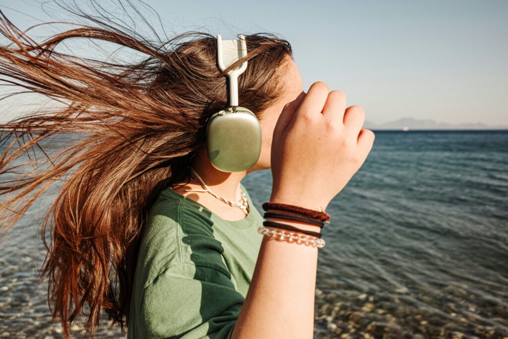 Woman adapting to wind-sound and sun glare at the waterfront.